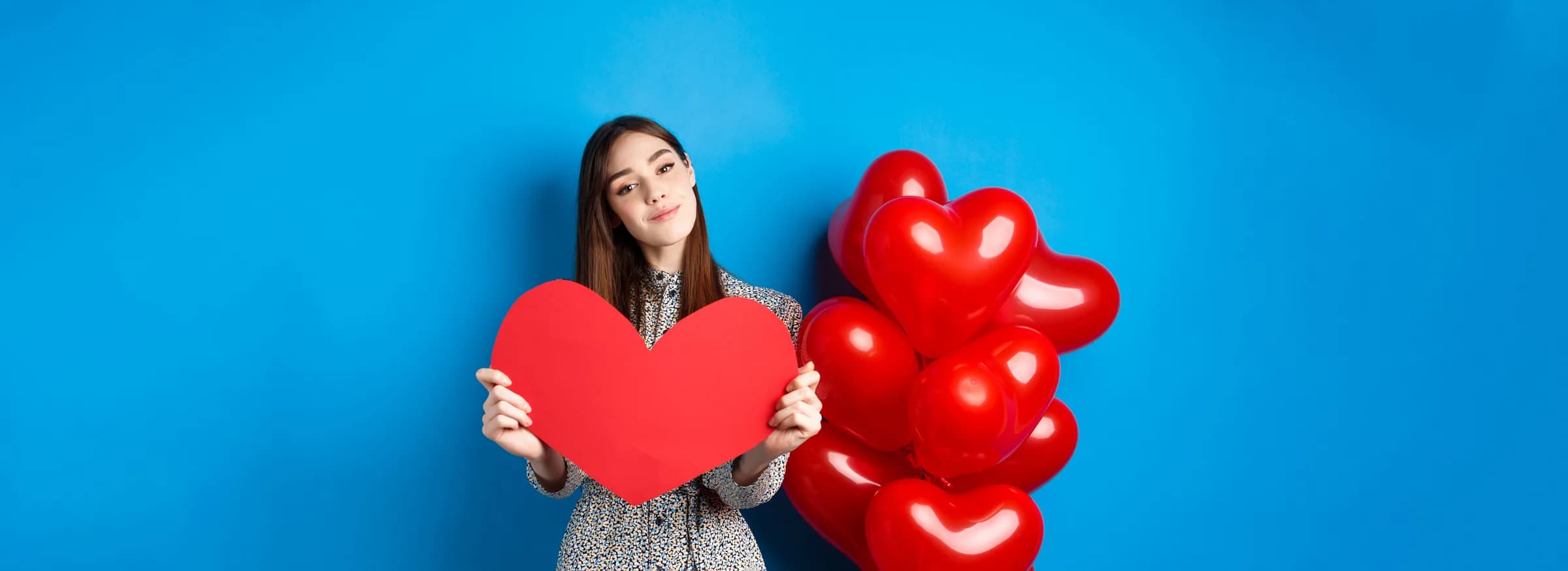 Contáctenos — Regalitos con Amor, Medellín Mujer sosteniendo un corazón rojo entre globos — contacta a Regalitos con Amor en Medellín