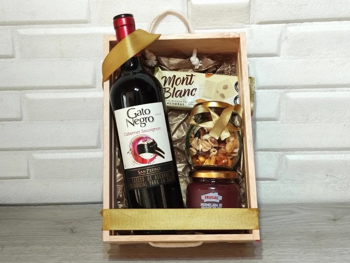 Guacal de madera con vino Gato Negro, frutos secos, Nutella y barquillos