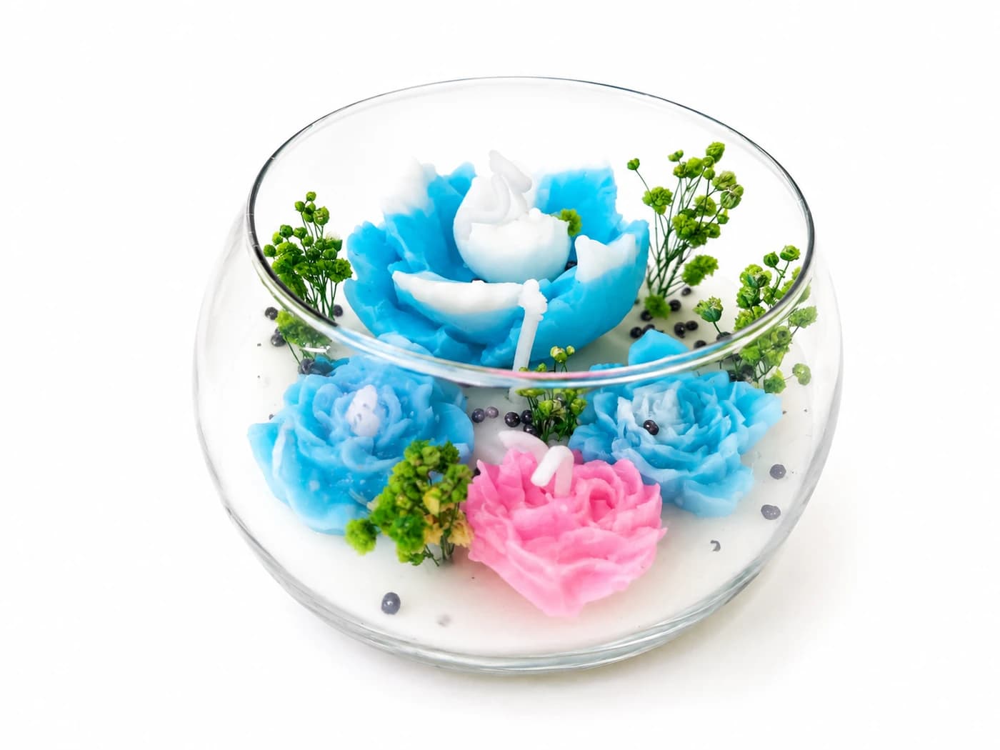 Velas aromáticas en forma de flores sobre base de vidrio tipo cúpula con detalles naturales